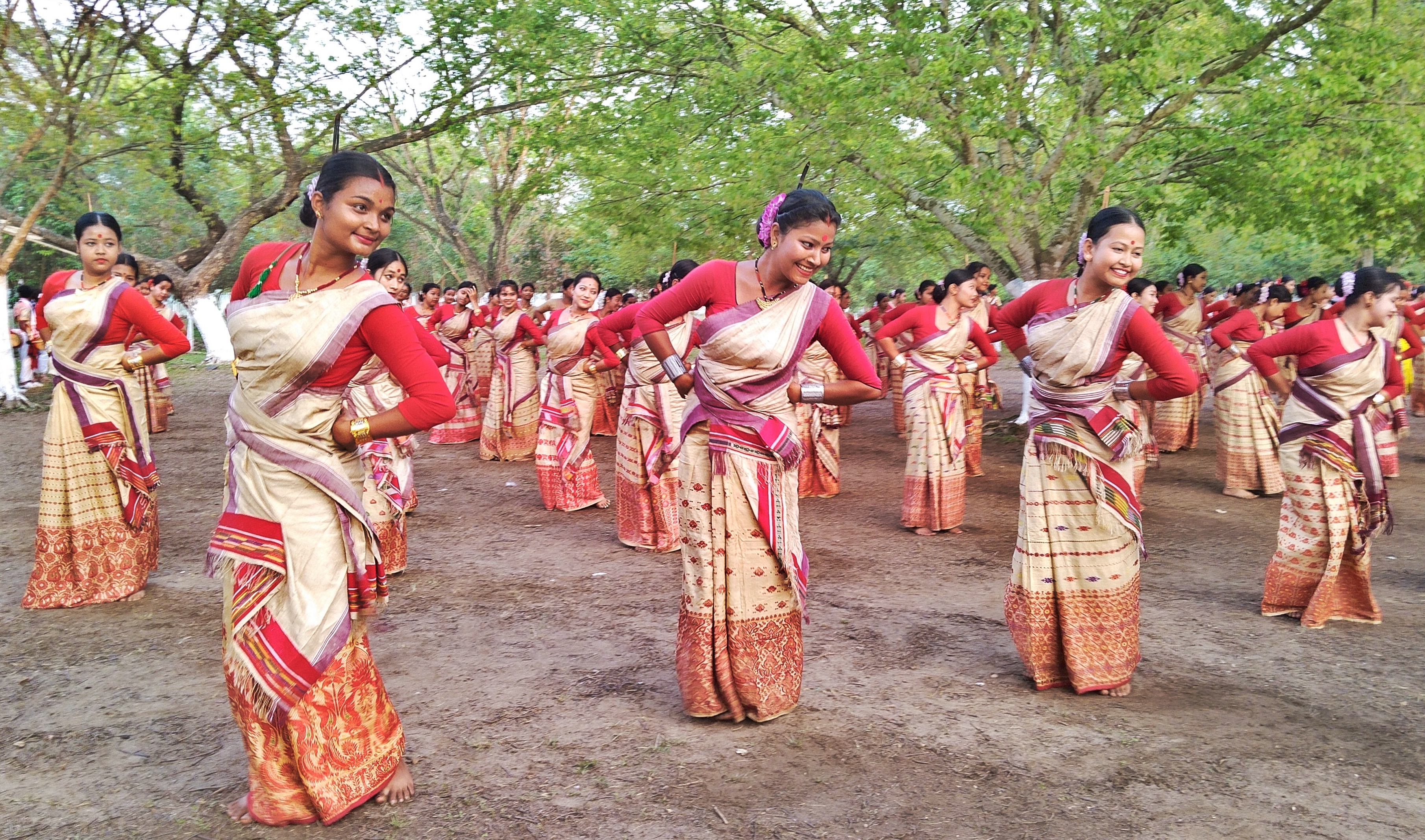 Bihu dancers in red and cream Assamese attire in Dhakuakhana